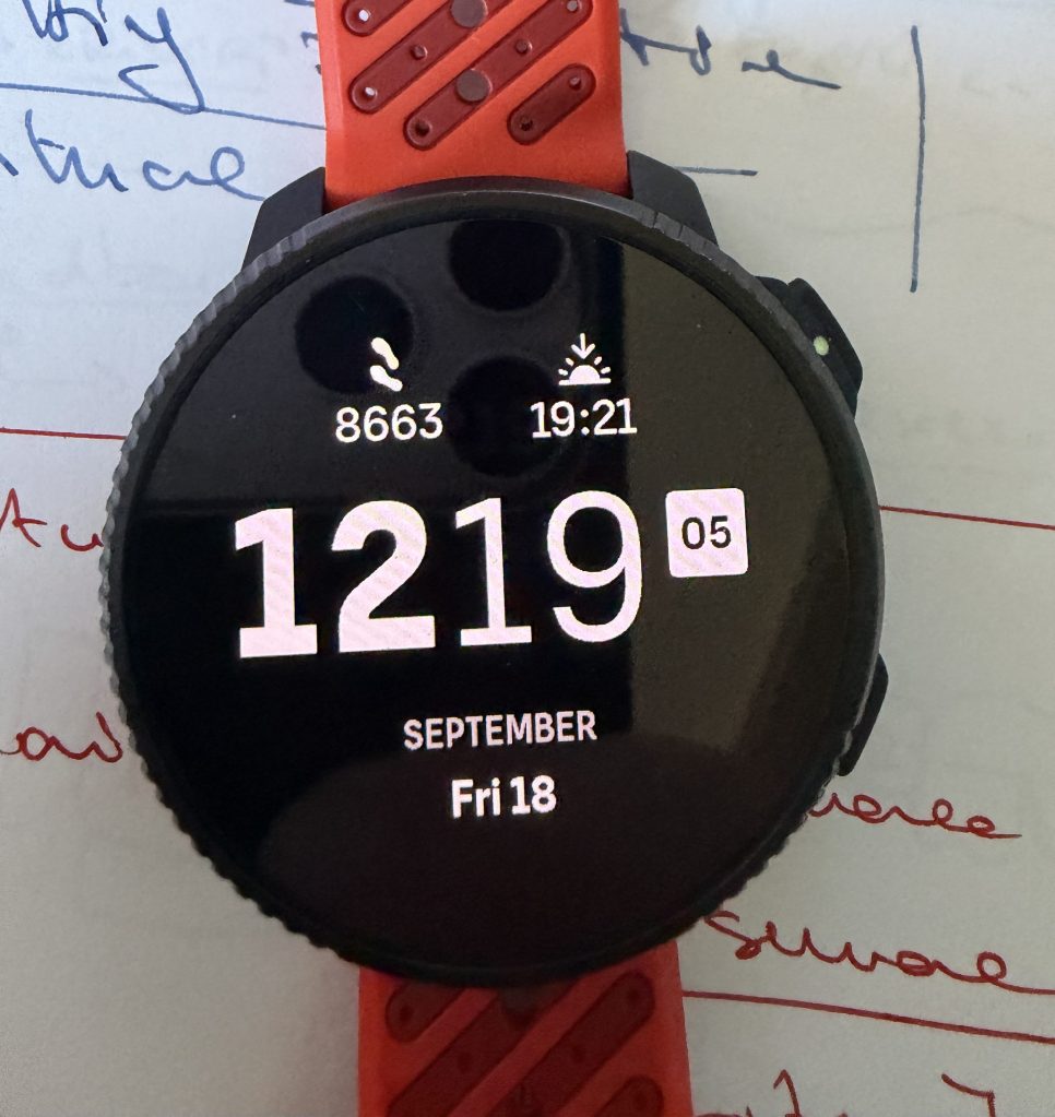 A smartwatch displaying the date 'September 18', time '19:21', and a step count of '8663' on a black screen with a red strap.